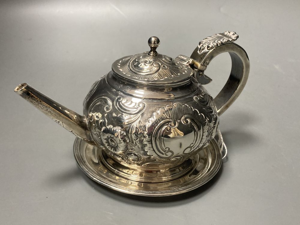 A George III Irish embossed silver bachelors teapot, James Scott, Dublin, 1804, on an associated Irish silver circular stand, 9oz.
